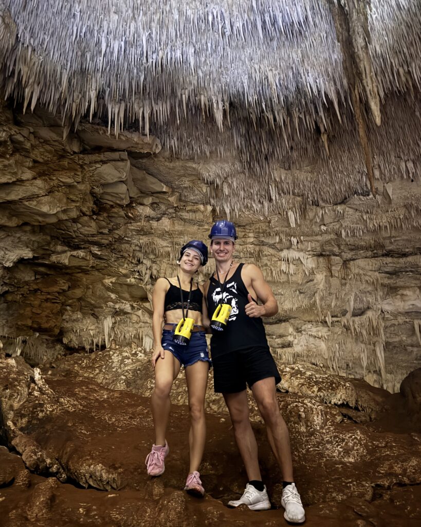 Couple exploring a cave, embracing life abroad while working online
