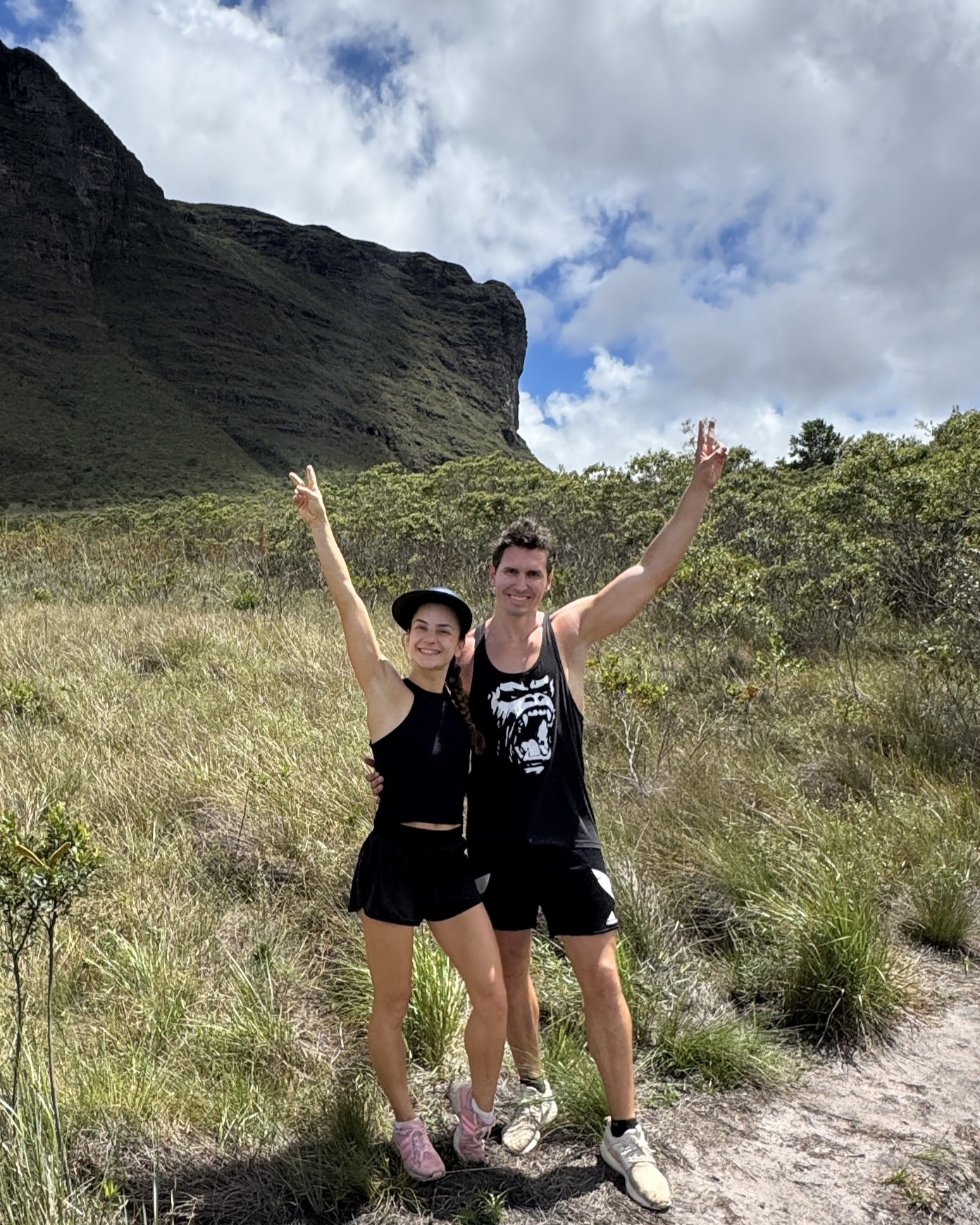 Couple hiking with a mountain backdrop, celebrating life abroad